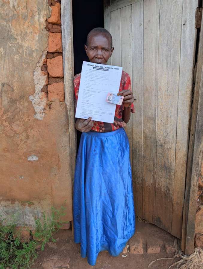 An older woman holding a signed request form asking for support.