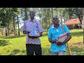 Two people standing outdoors and presenting the June 2026 school distribution report.